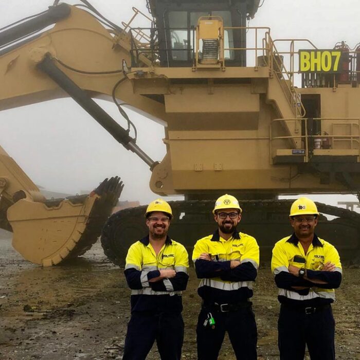 workers standing in front of heavy duty equipment