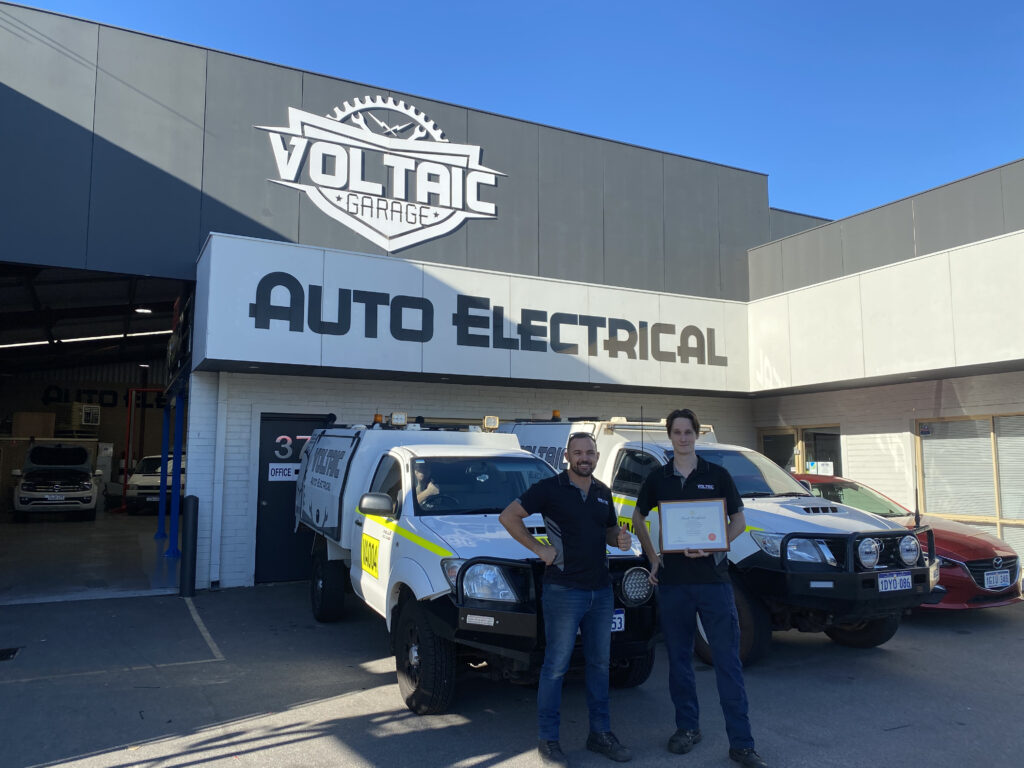 Voltaic apprentice standing proud with his certificate outside the workshops