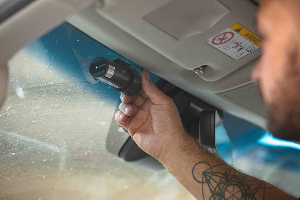 Close up of a voltaic employee installing a Dash camera into a vehicle