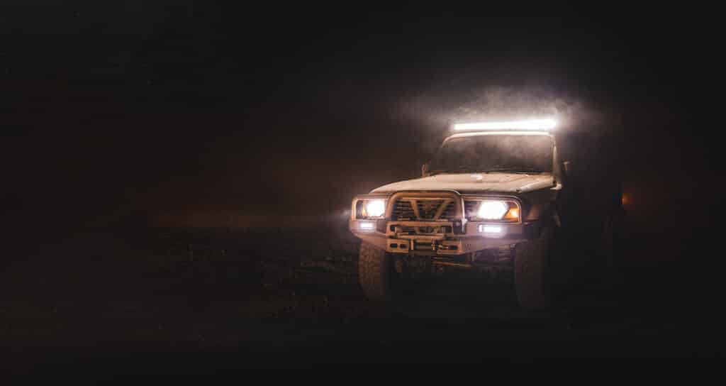 An off road vehicle lit up well at night