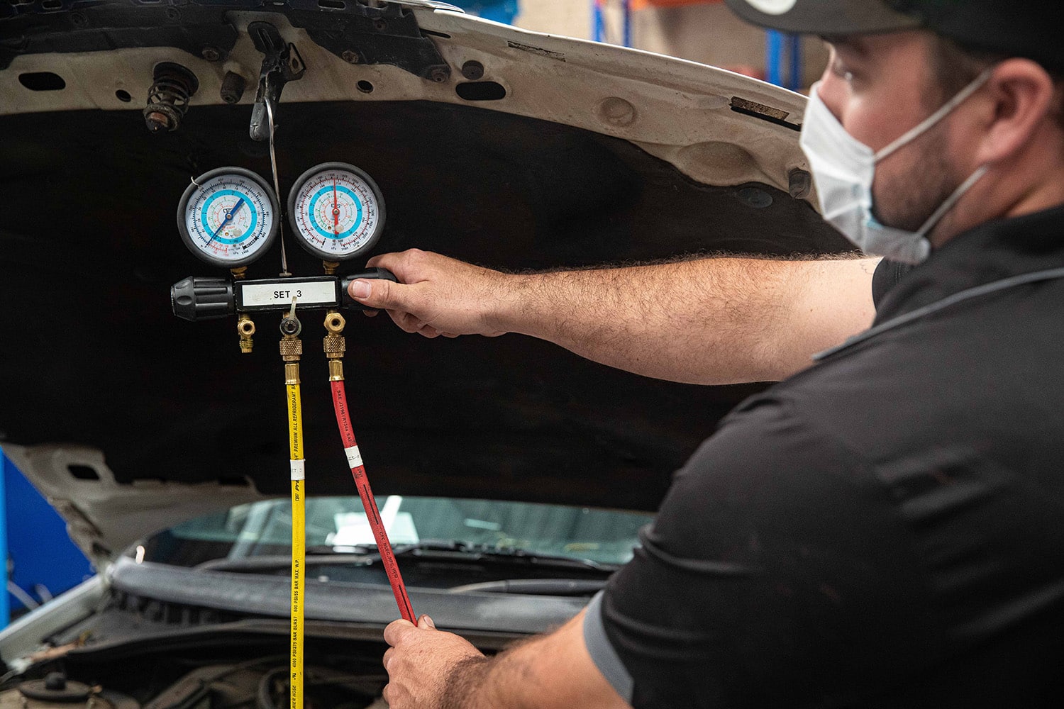A voltaic employee performing an air conditioning re-gas in an off-road vehicle