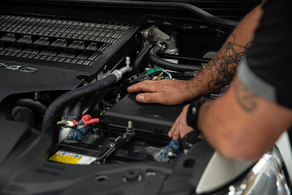 A voltaic employee installing important car parts in the engine of a vehicle
