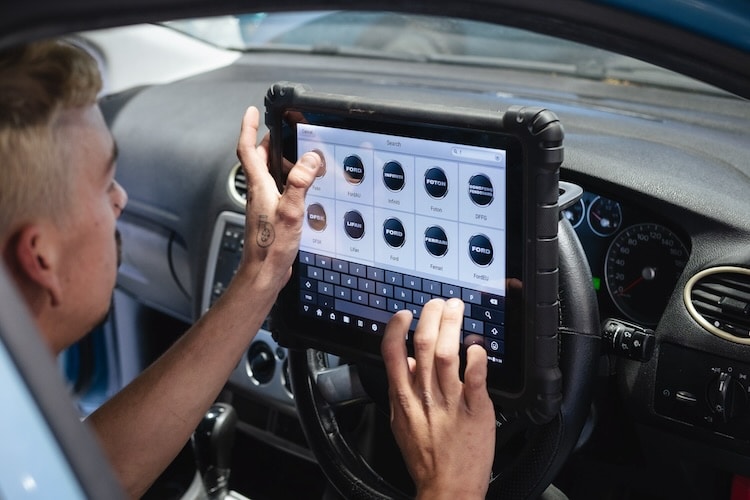 Electrician viewing a car diagnostic test on a screen